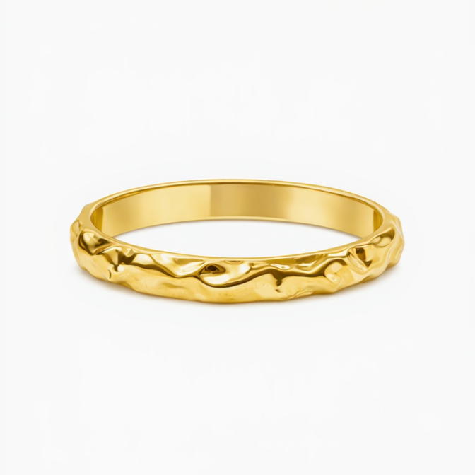 Gold ring with a textured design on a white background