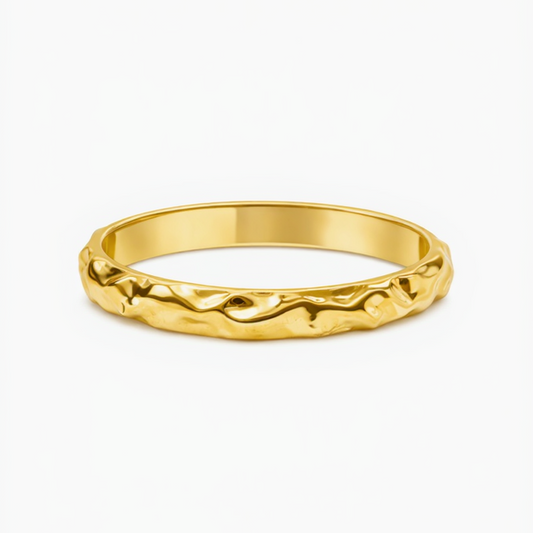 Gold ring with a textured design on a white background