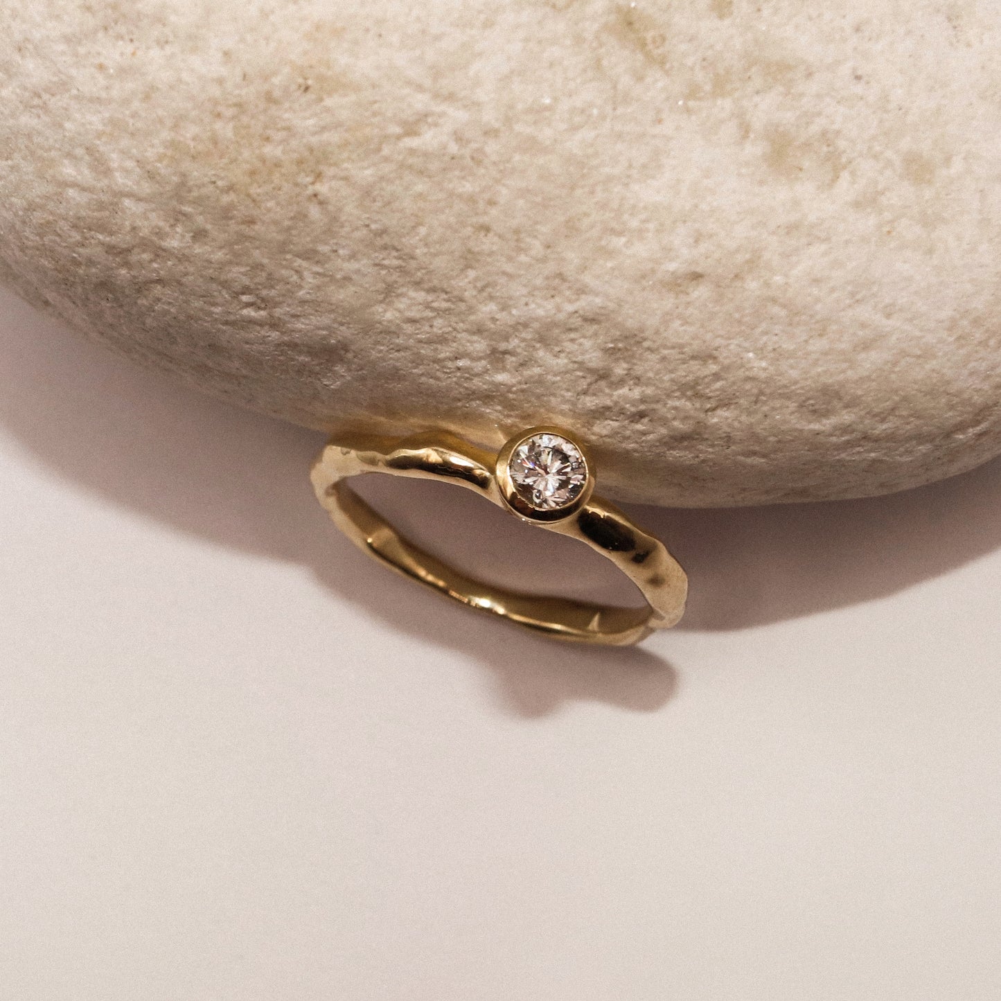 Gold ring with a diamond on a stone background