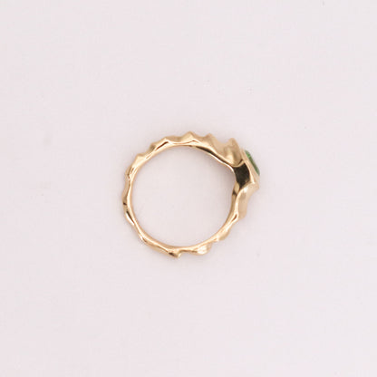 Gold ring with a textured design on a light gray background