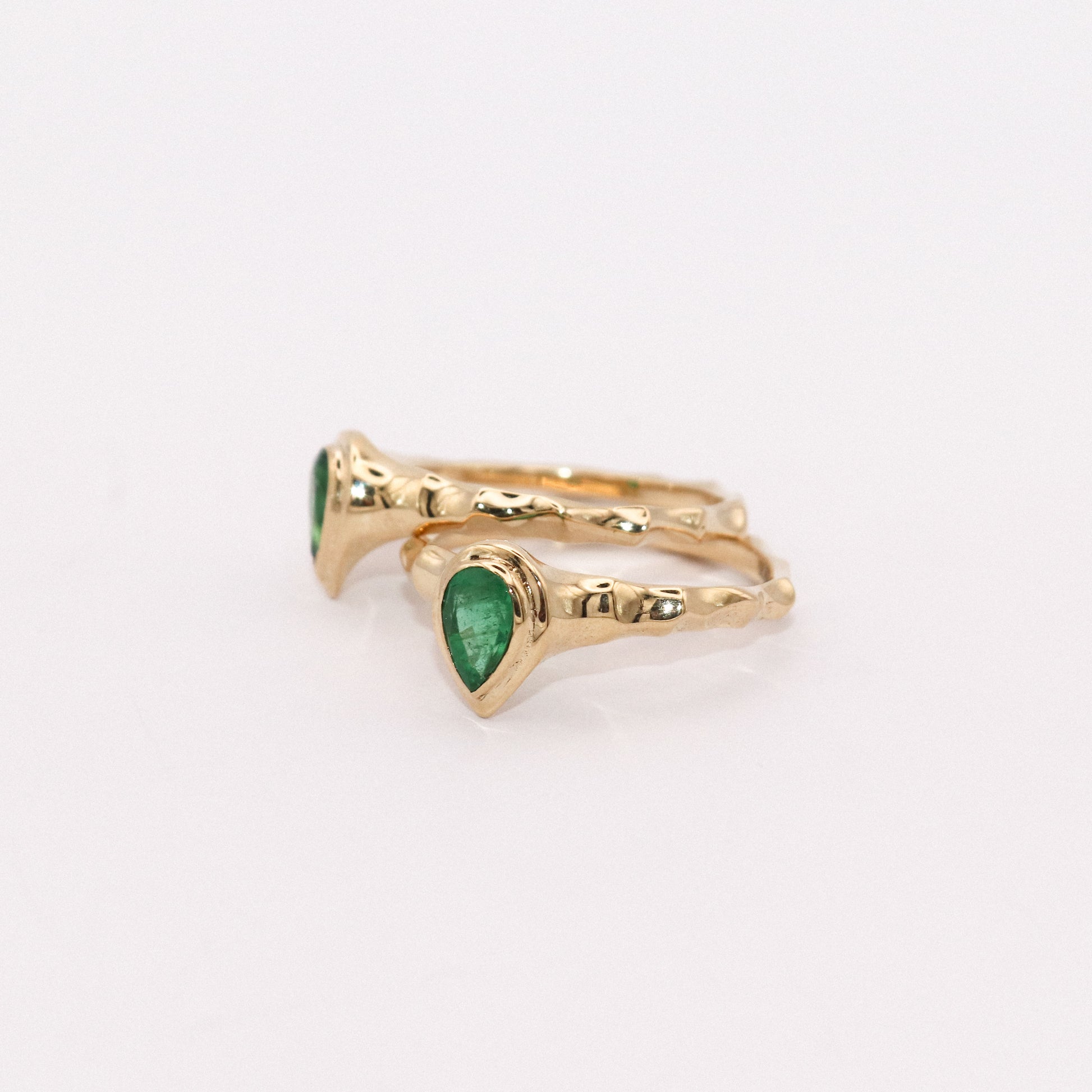 Gold ring with green gemstone on a white background