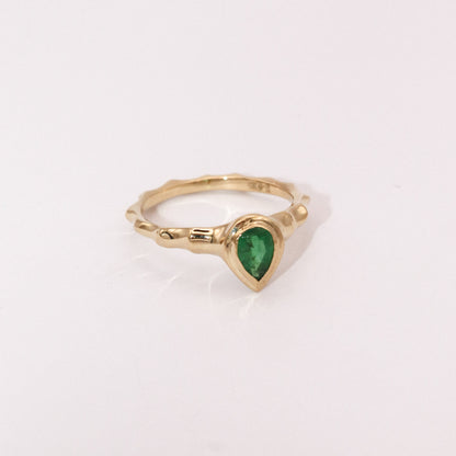 Gold ring with a green gemstone on a white background