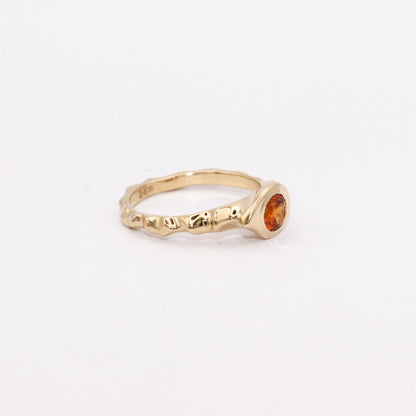 Gold ring with a gemstone on a light gray background