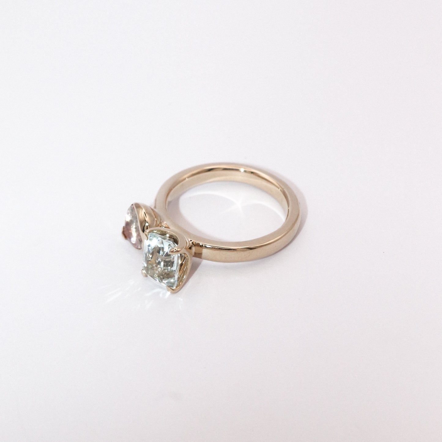 Gold ring with a heart-shaped green gemstone on a white background