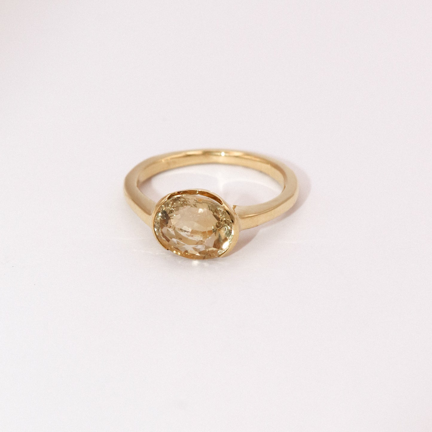 Gold ring with a round gemstone on a white background