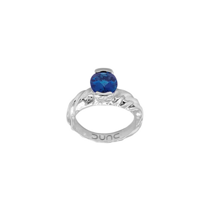 A silver rhodium-plated ring with an oval cut blue Indicolite tourmaline stone.