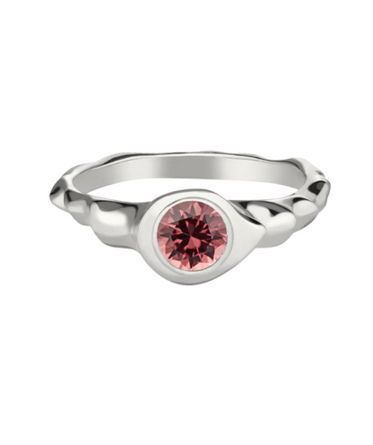 A polished, rhodium-plated 925 silver ring with a round cut pink Malaya garnet stone in the center.