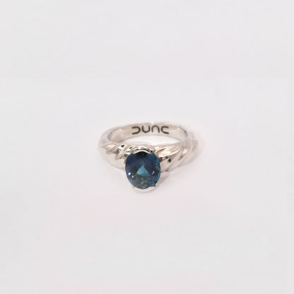 Silver ring with a blue gemstone on a white background
