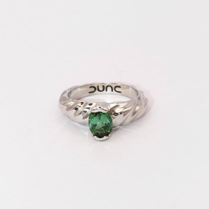 Silver ring with a green gemstone on a white background