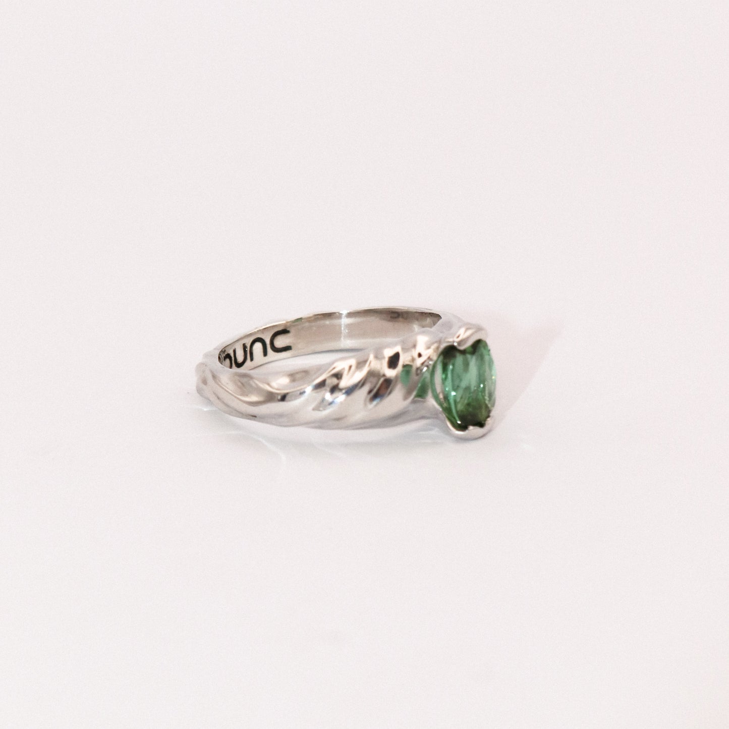 Silver ring with a green gemstone on a white background