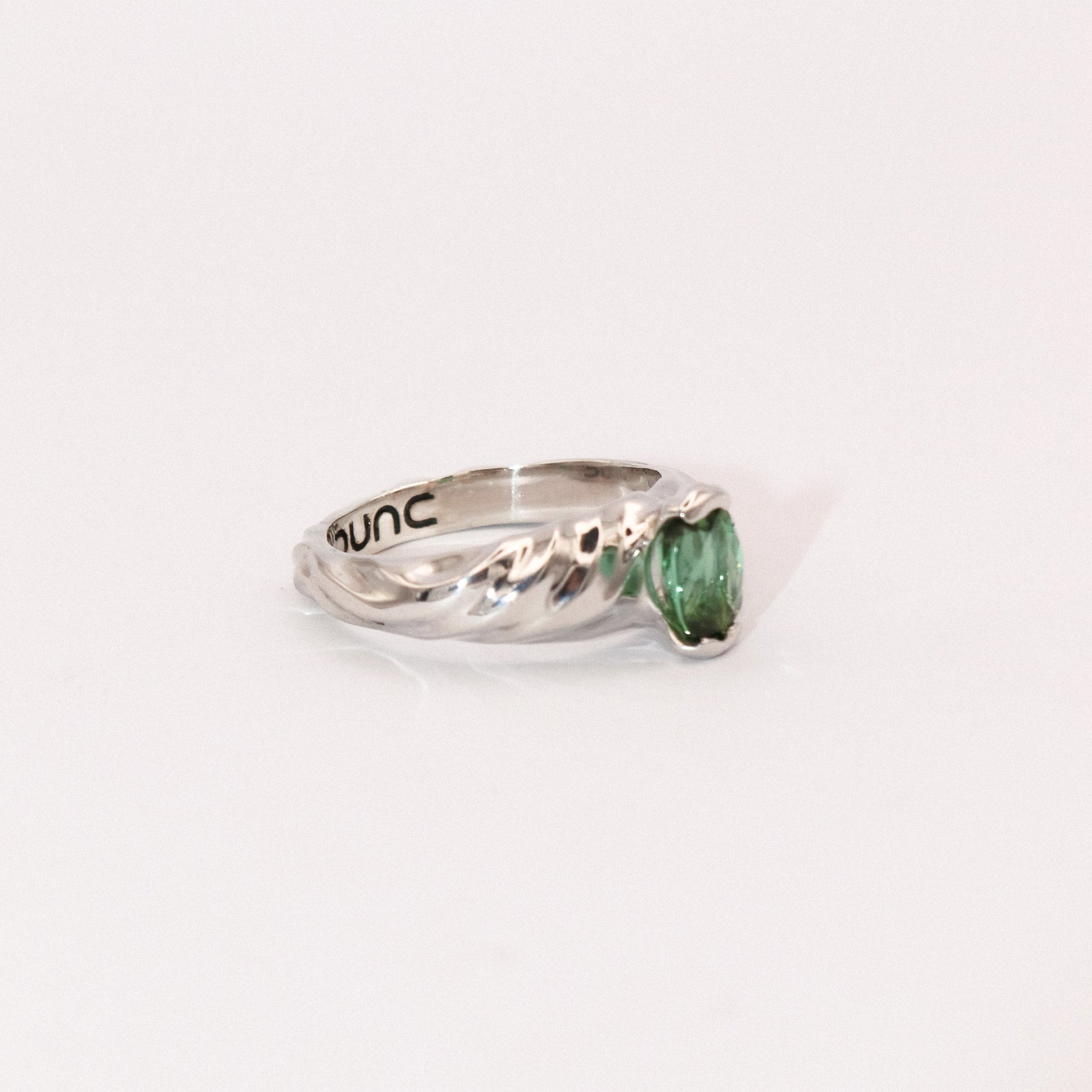Silver ring with a green gemstone on a white background