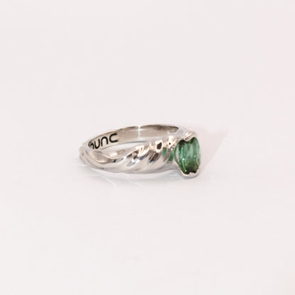 Silver ring with a green gemstone on a white background