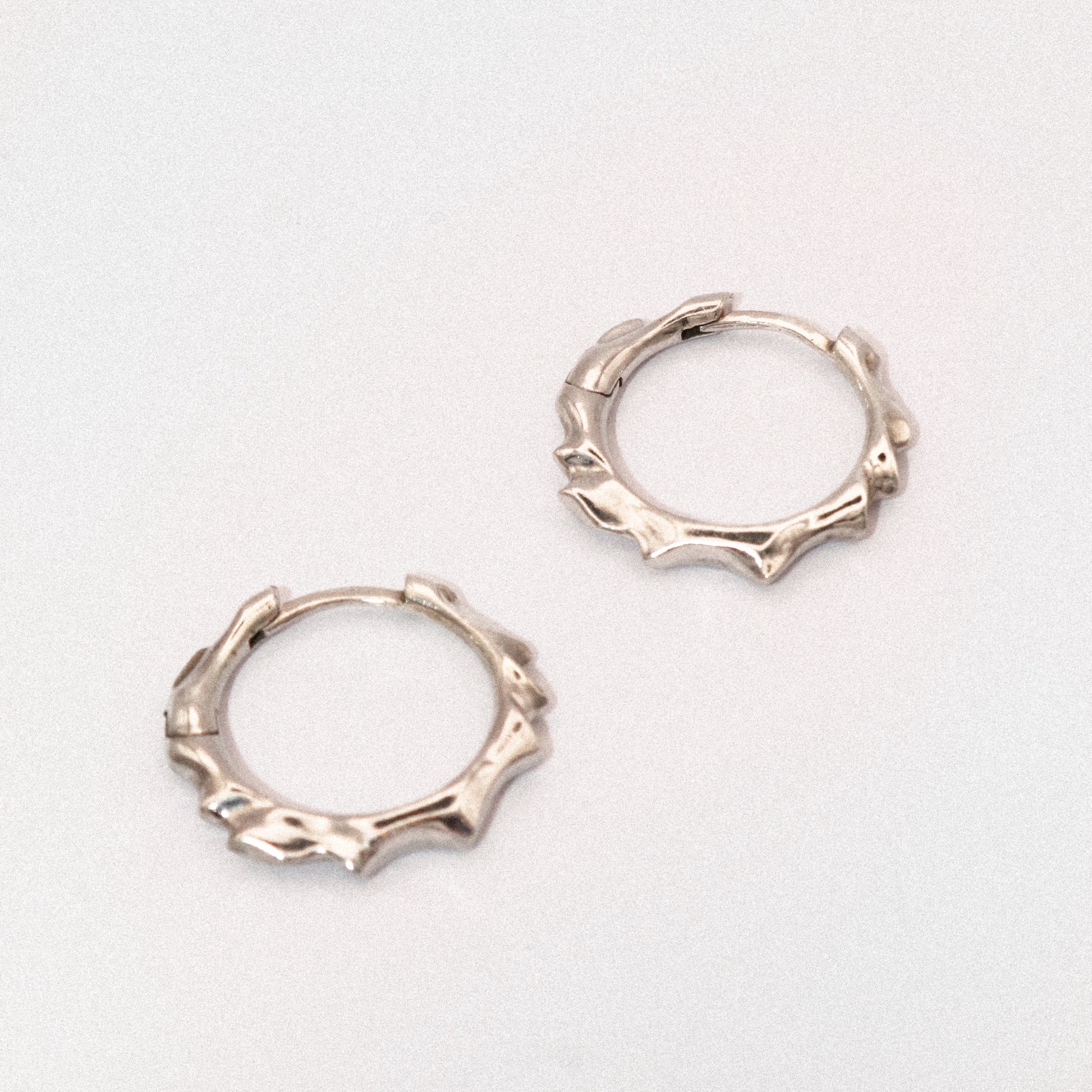 Pair of silver hoop earrings on a light gray background