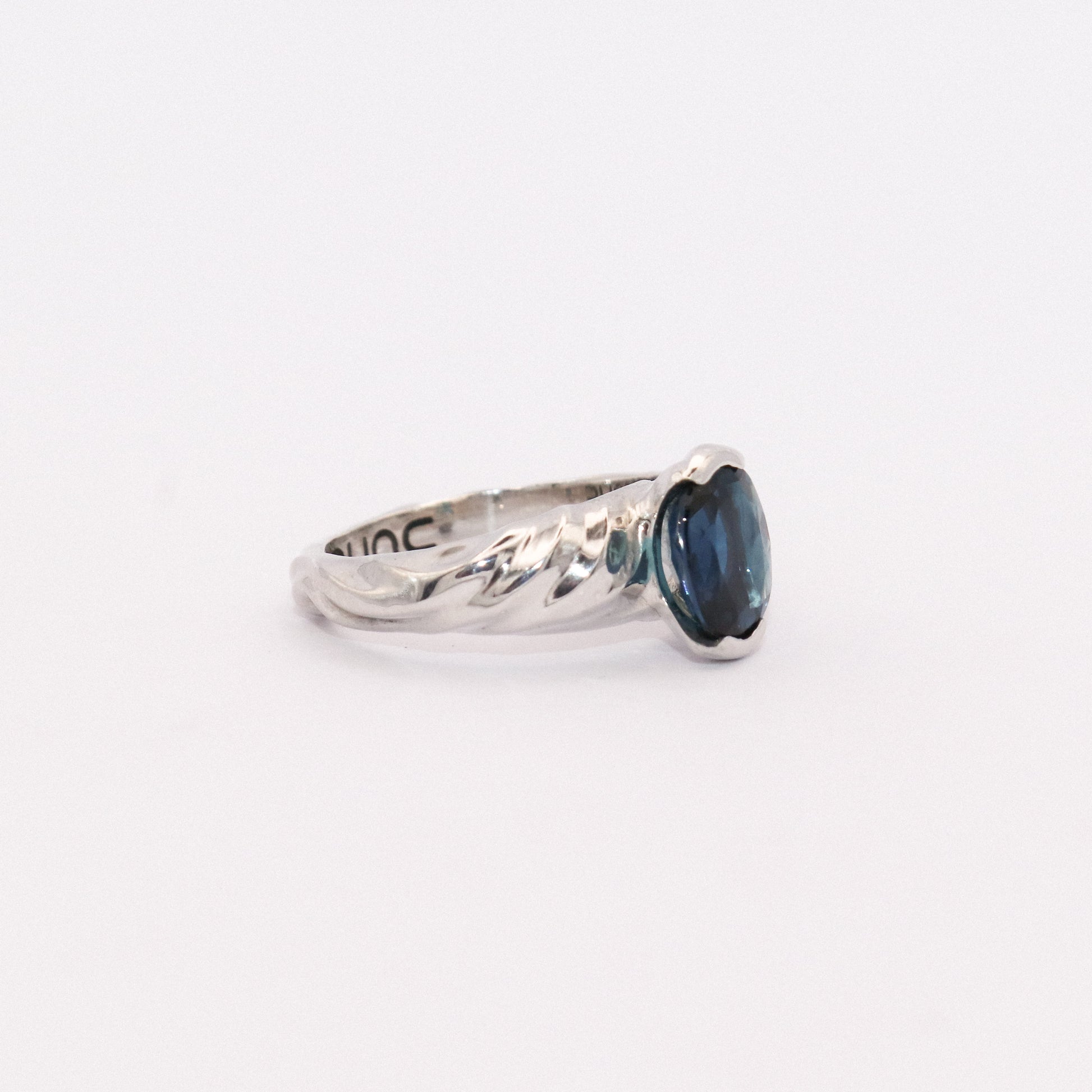 Silver ring with a blue gemstone on a white background