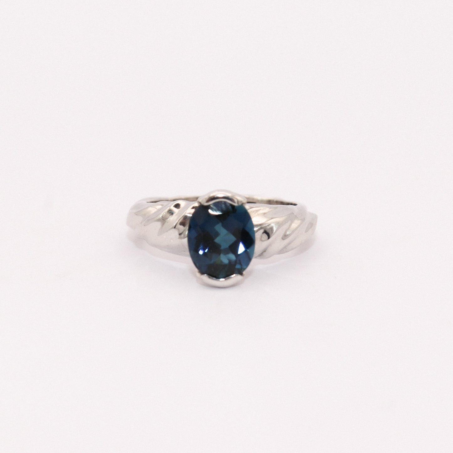 Silver ring with a blue gemstone on a white background