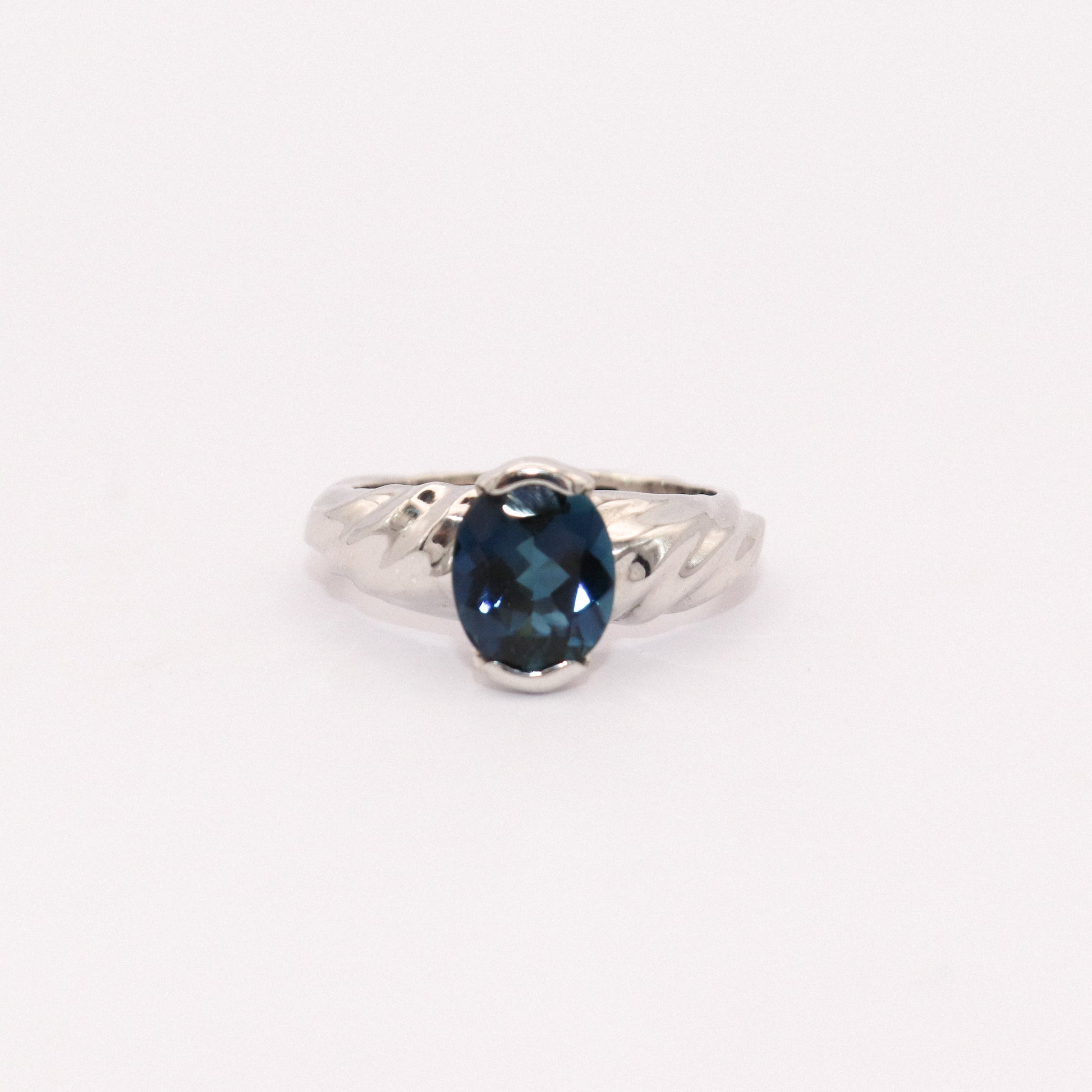 Silver ring with a blue gemstone on a white background