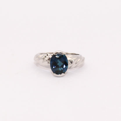 Silver ring with a blue gemstone on a white background