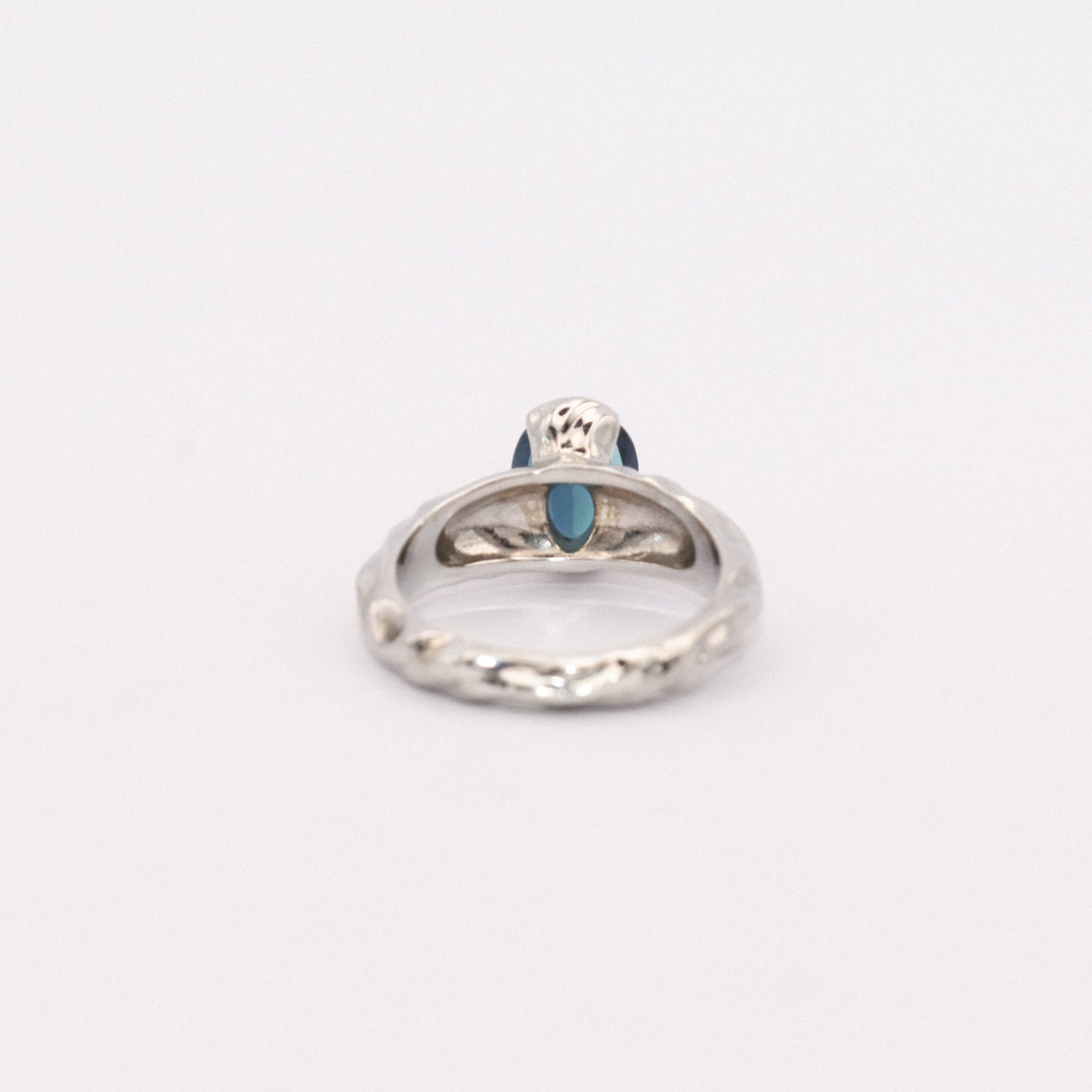 Silver ring with a blue gemstone on a white background