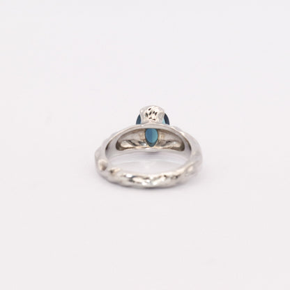 Silver ring with a blue gemstone on a white background