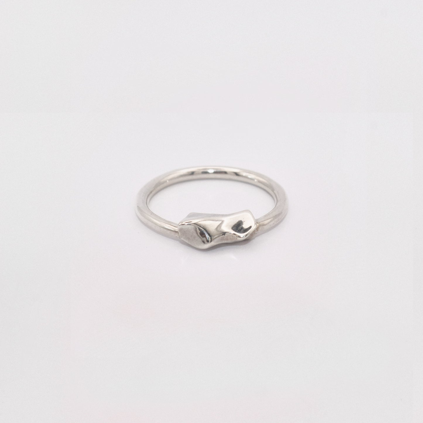 Silver ring on a light gray background