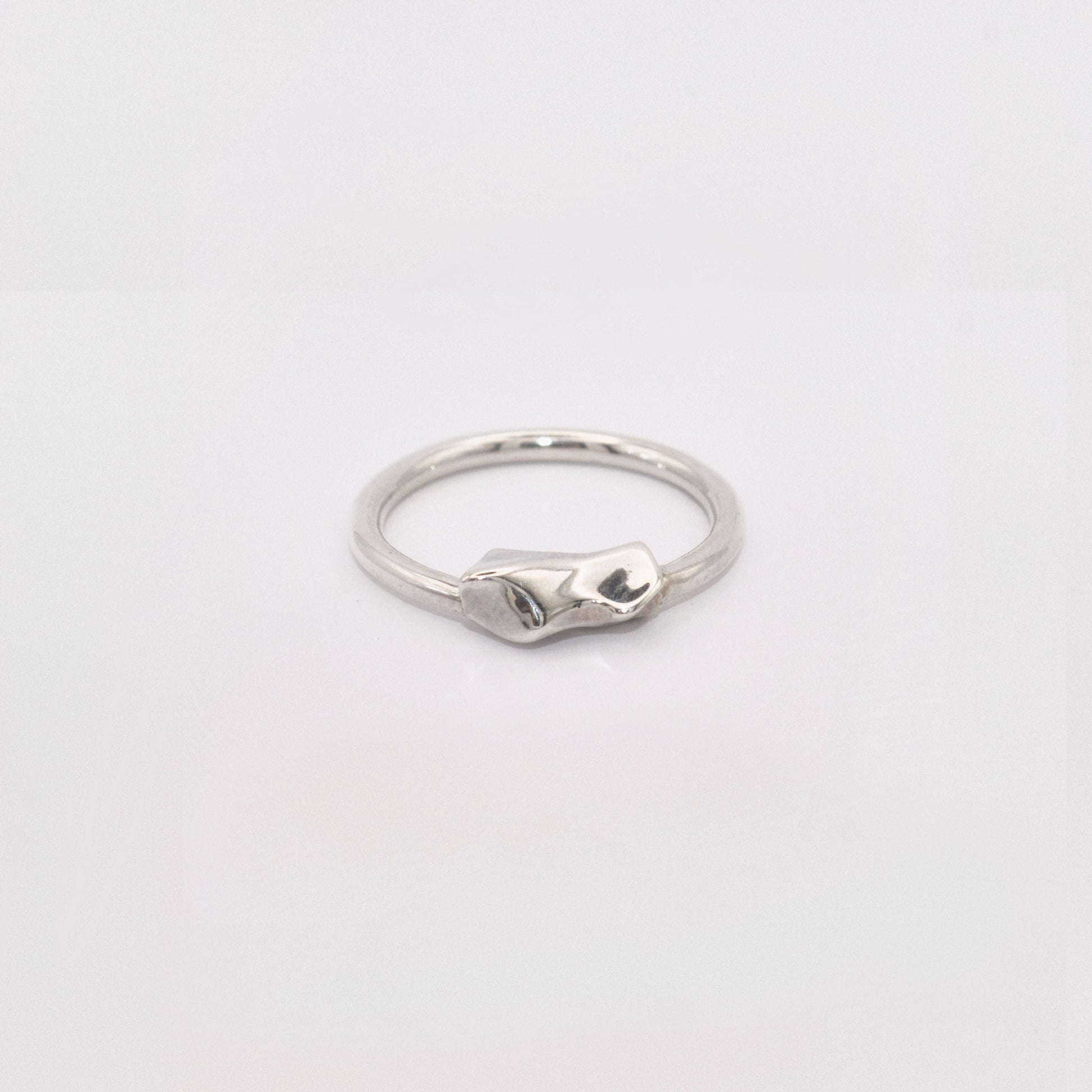 Silver ring on a light gray background