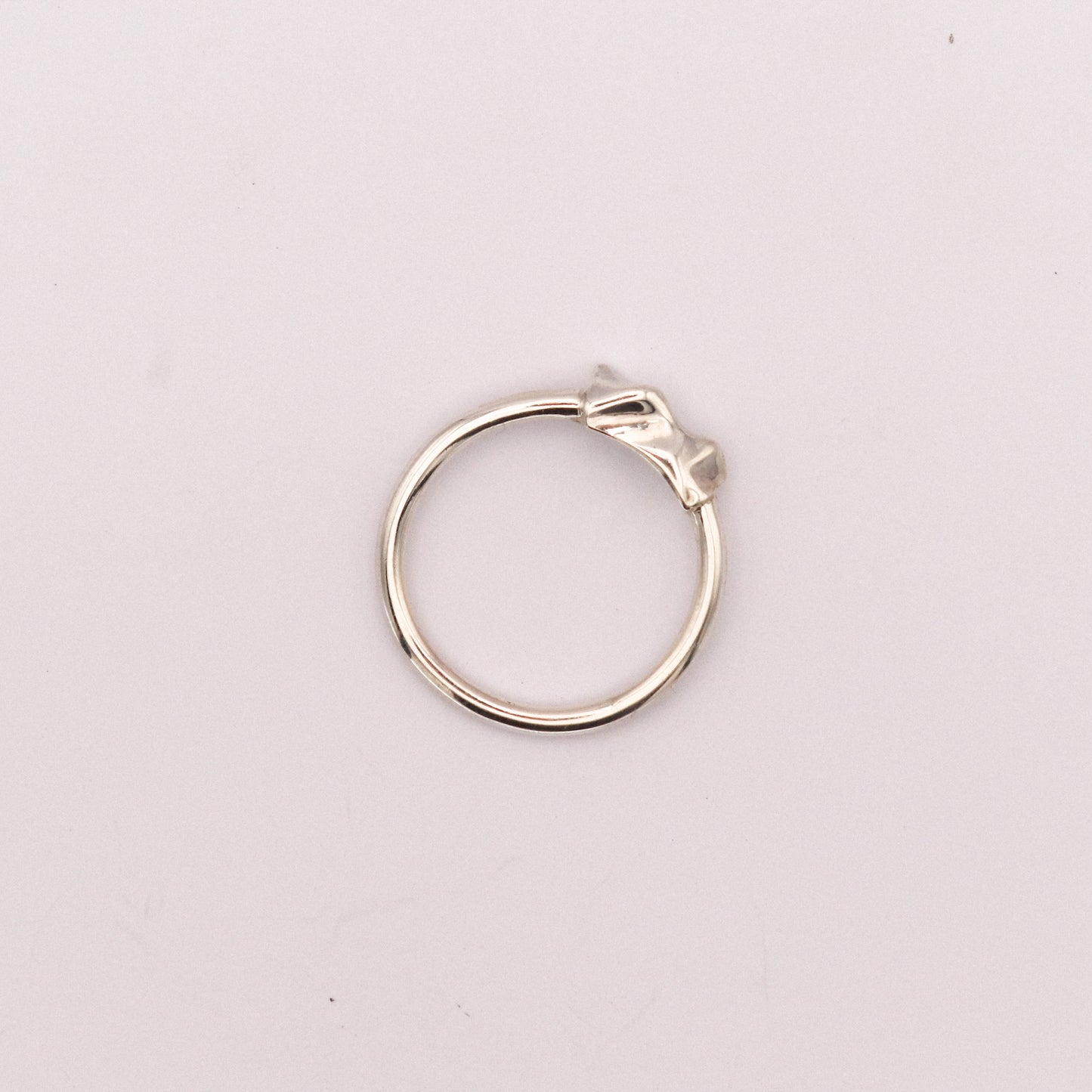 Silver ring on a light pink background