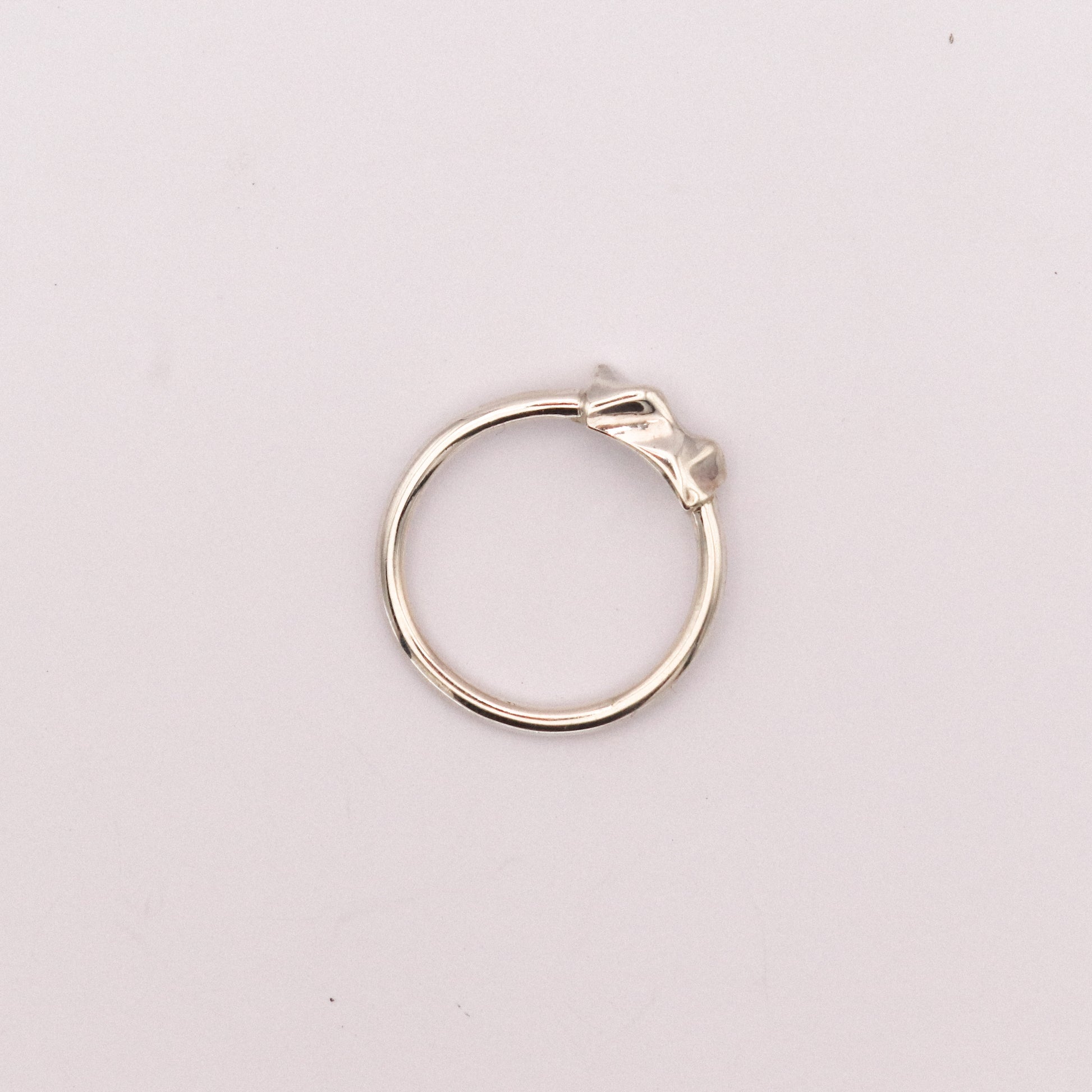 Silver ring on a light pink background