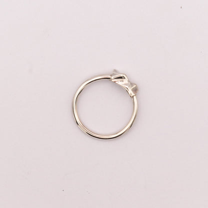 Silver ring on a light pink background