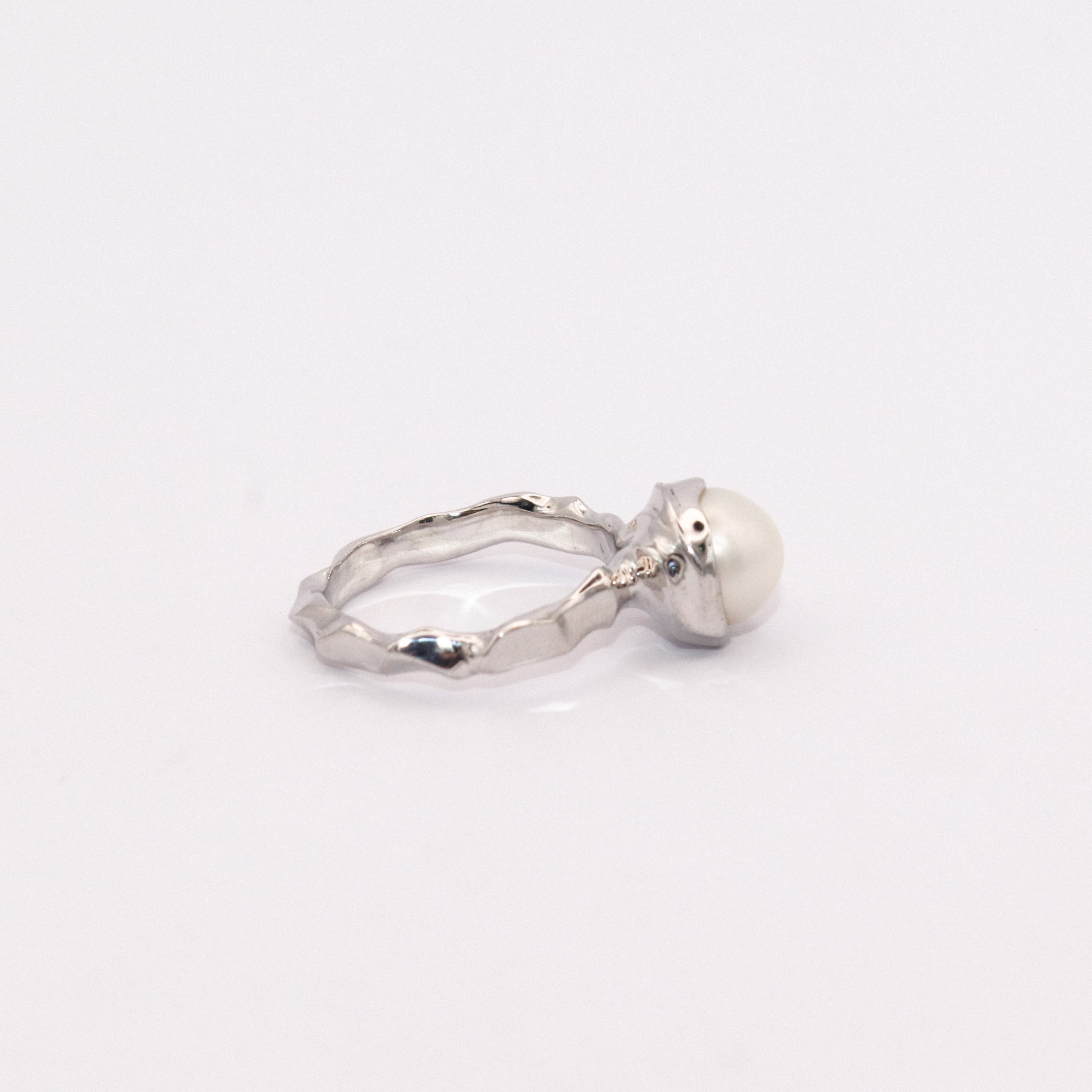 Silver ring with a pearl on a white background
