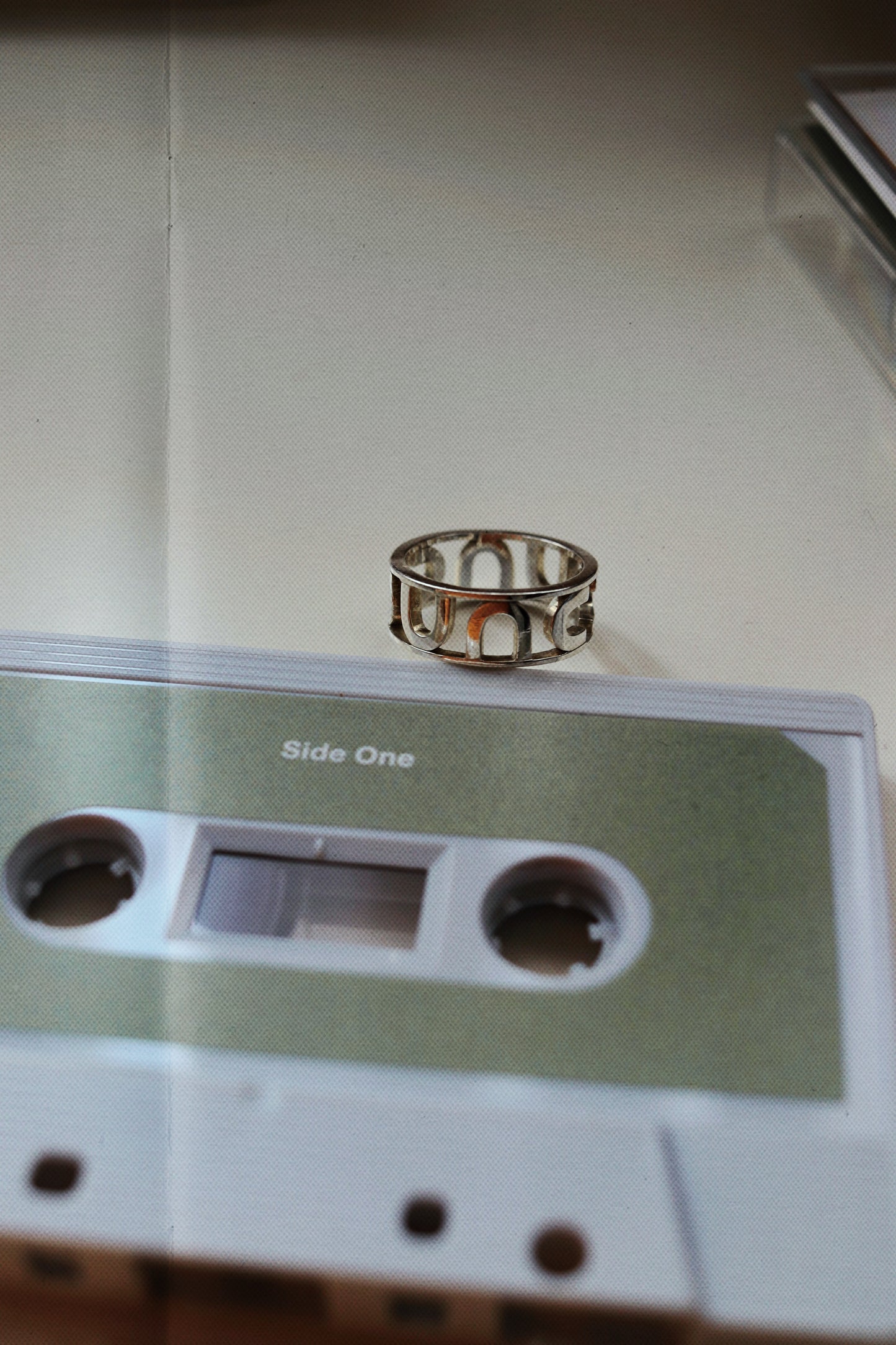 Silver ring on a vintage cassette tape with 'Side One' text.
