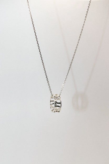 Silver necklace with a pendant on a light gray background