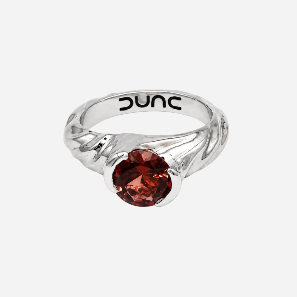 Silver ring with a red gemstone on a white background