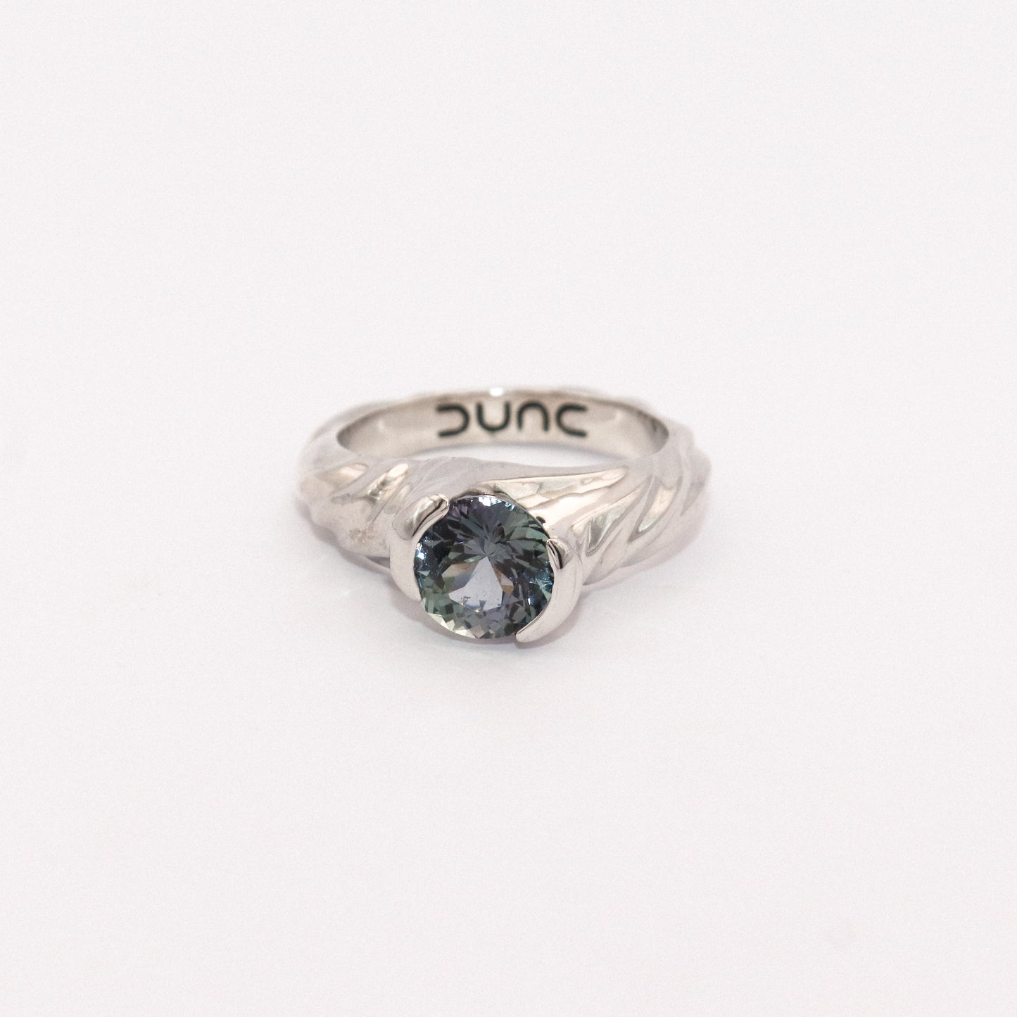 Silver ring with a blue gemstone on a white background