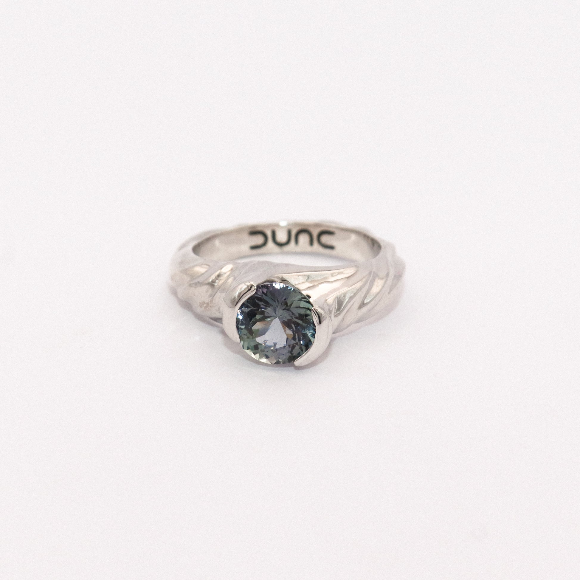 Silver ring with a blue gemstone on a white background
