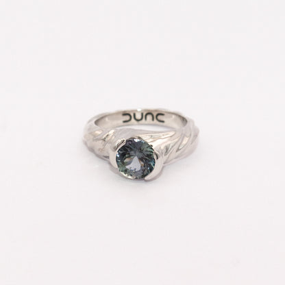 Silver ring with a blue gemstone on a white background