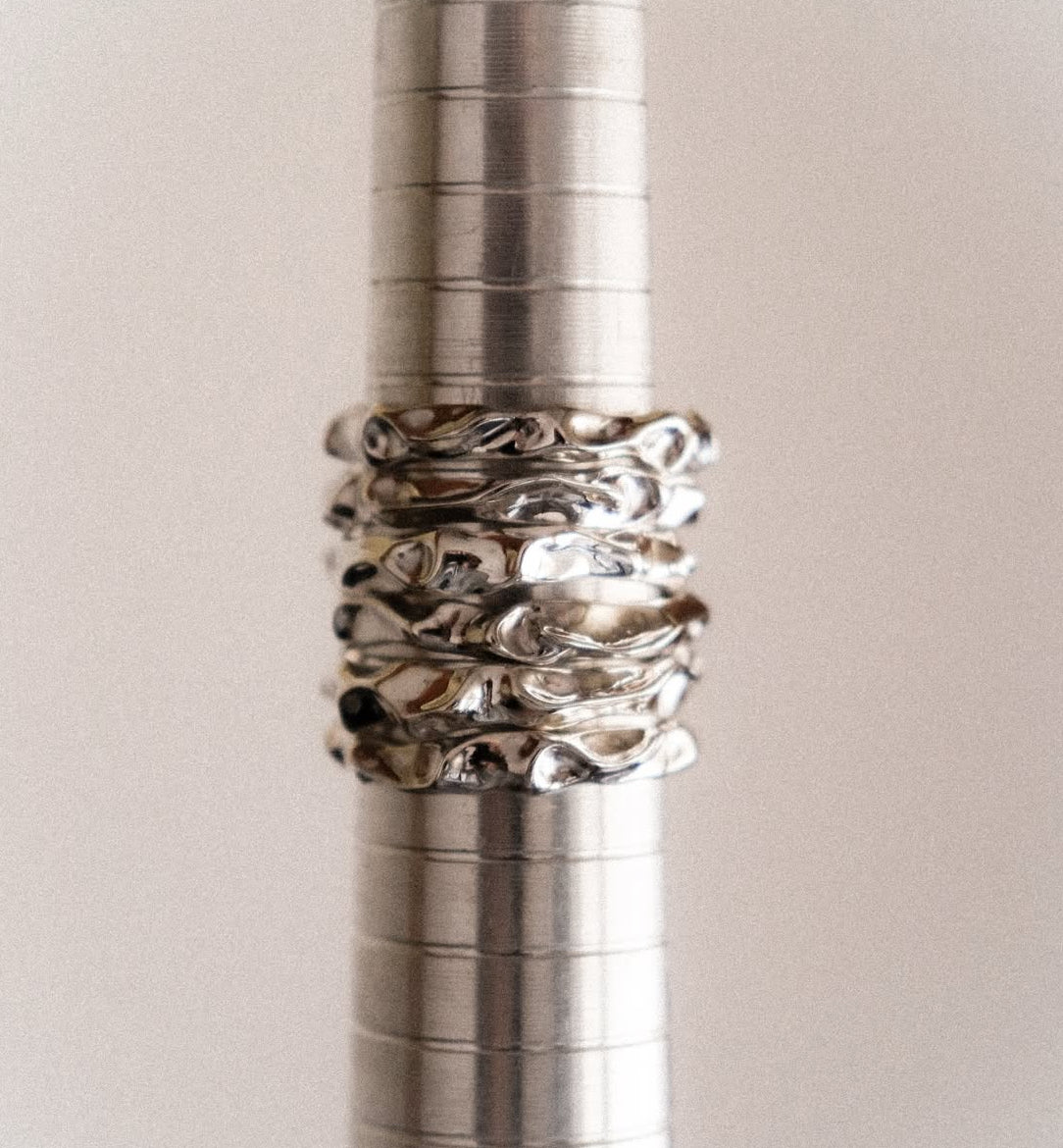 Close-up of a metallic pen with decorative rings on a light background