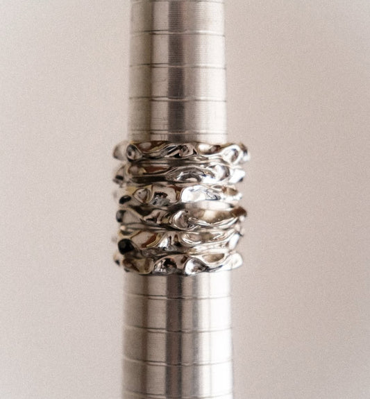Close-up of a metallic pen with decorative rings on a light background