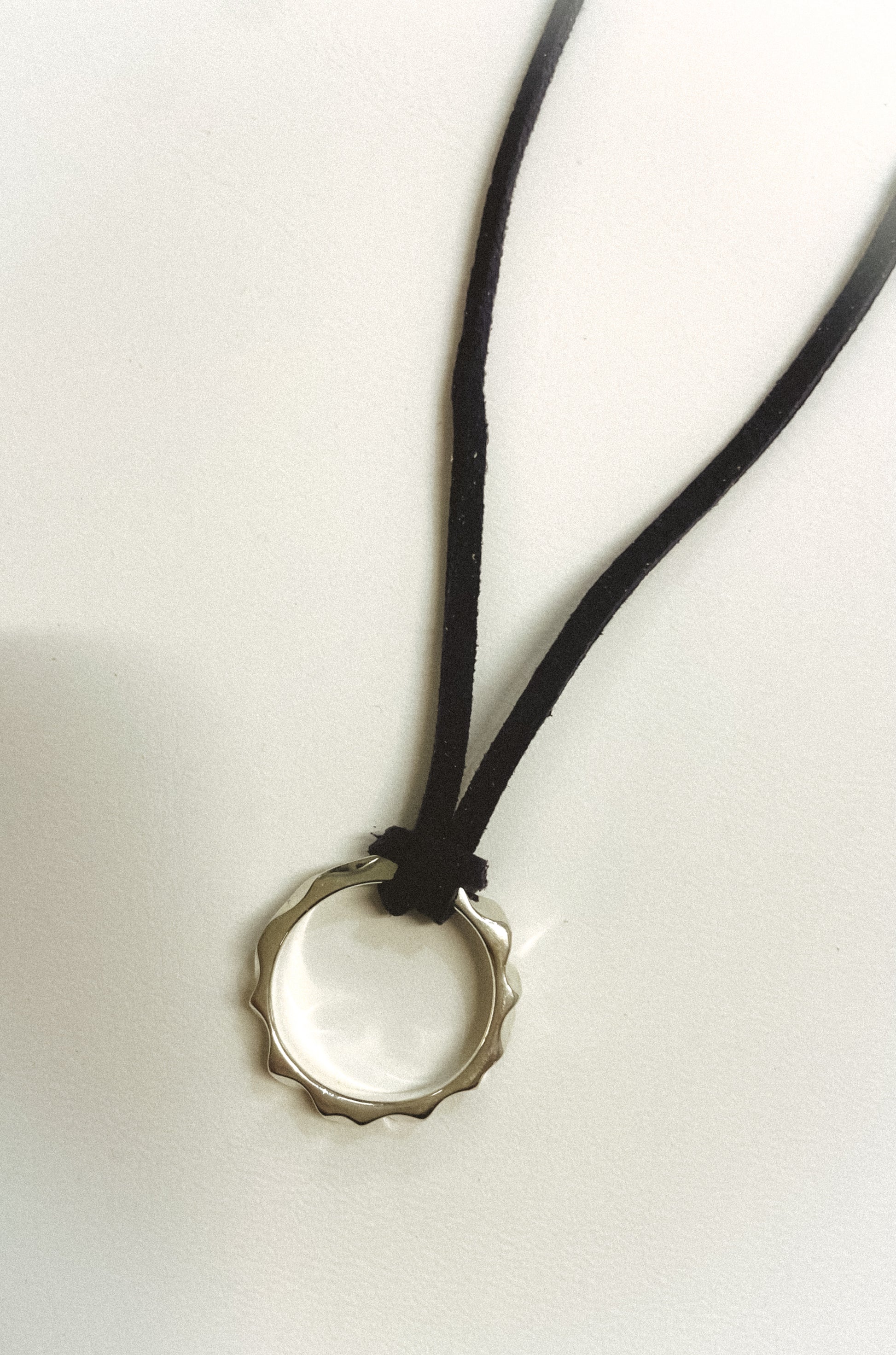 Necklace with a bottle cap pendant on a white background