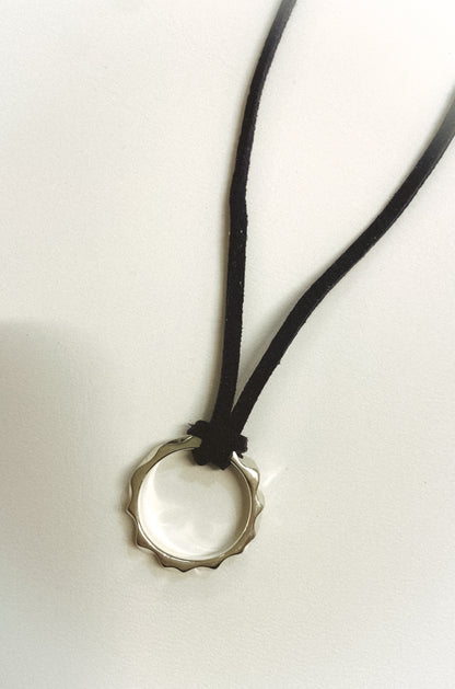 Necklace with a bottle cap pendant on a white background