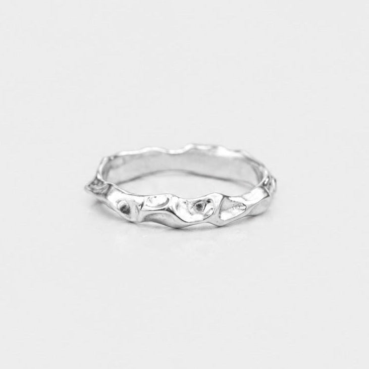 Silver ring with a unique design on a light gray background