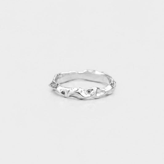 Silver ring with a unique design on a light gray background