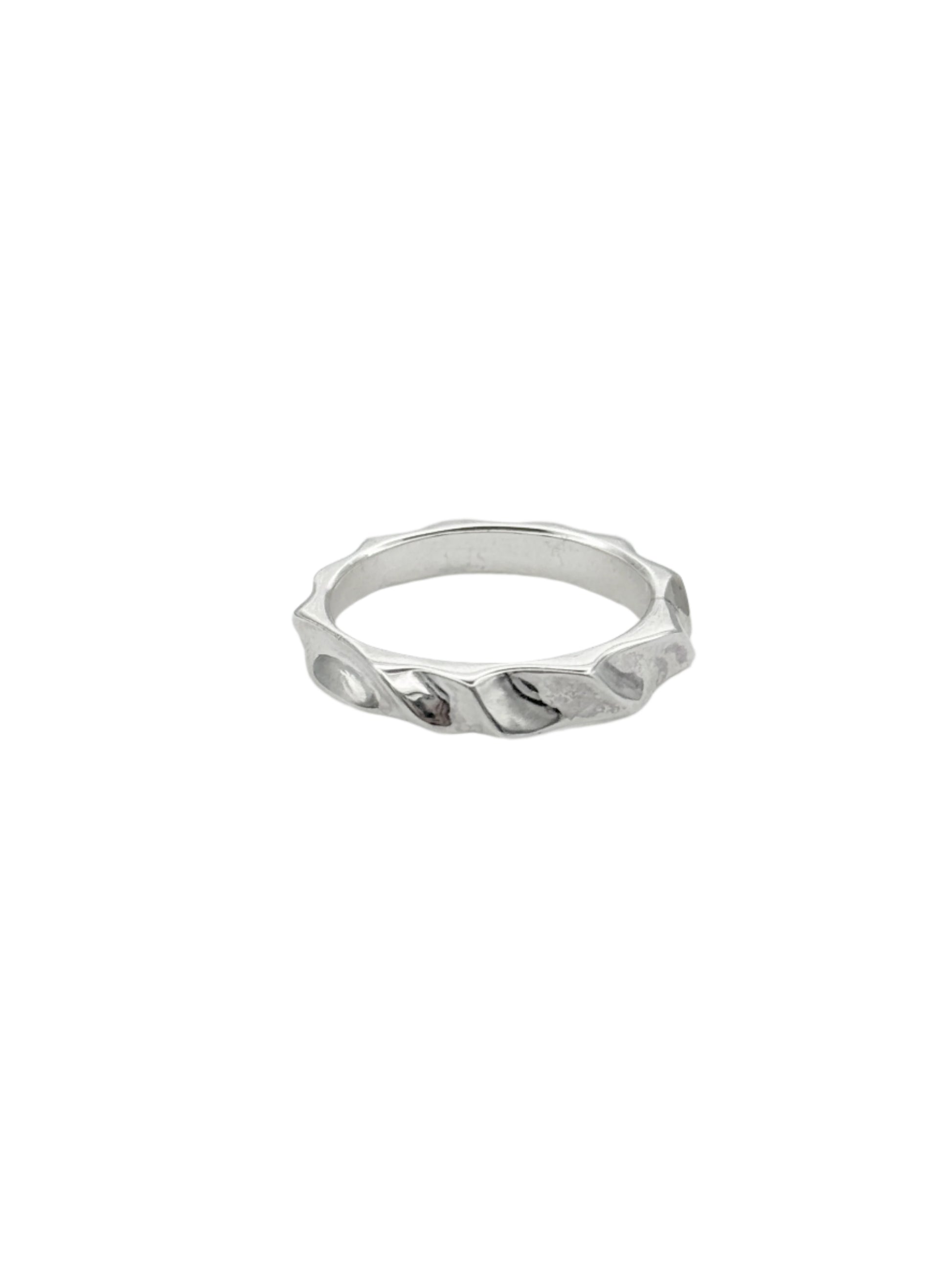 A silver ring with a hand-carved design featuring elegant curves and a rectangular profile.