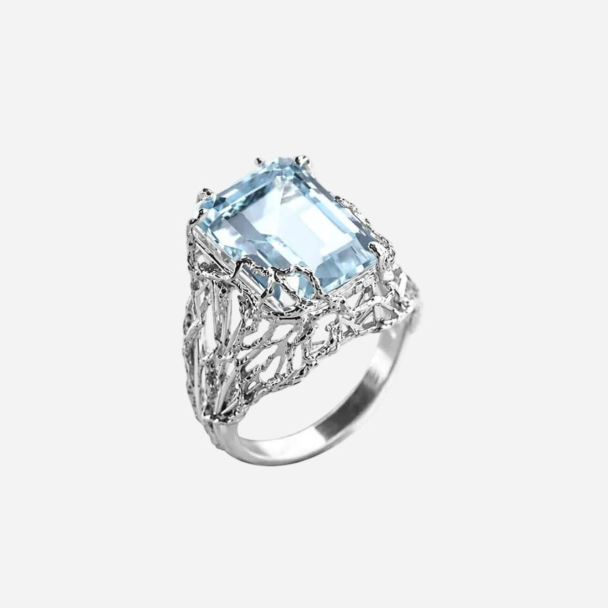 Silver ring with a large blue gemstone on a white background