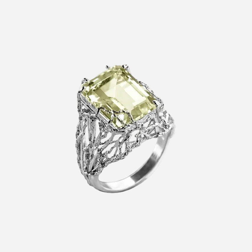 Silver ring with a green gemstone on a white background