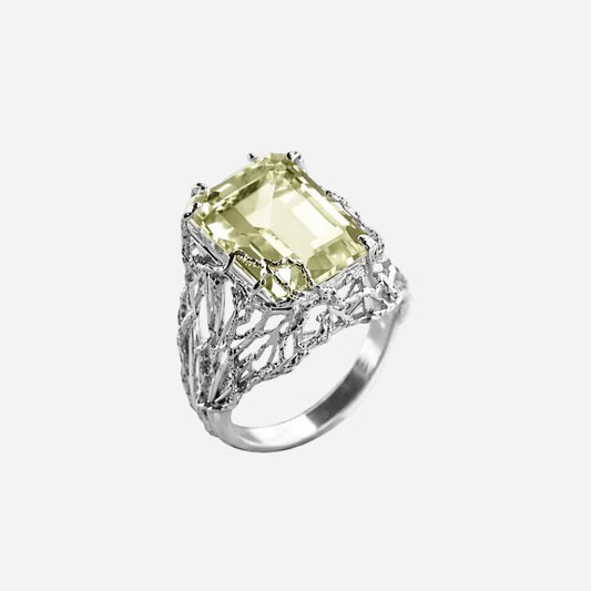 Silver ring with a green gemstone on a white background