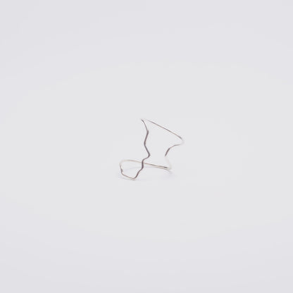 Small silver face profile ring on a light gray background