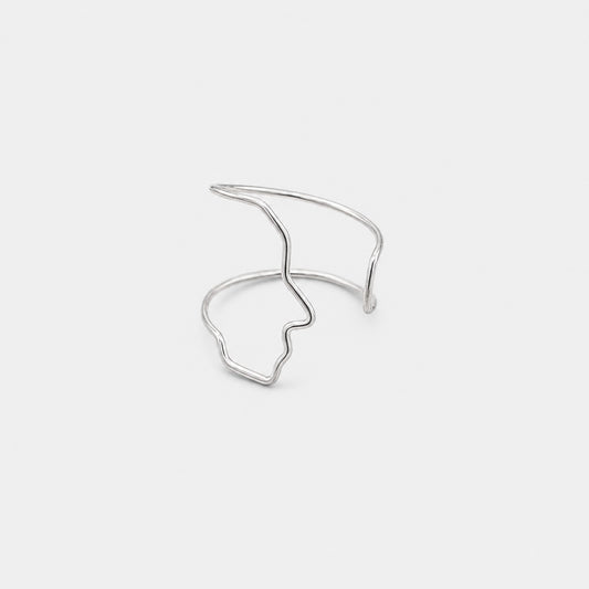 Silver open cuff bracelet on a light gray background