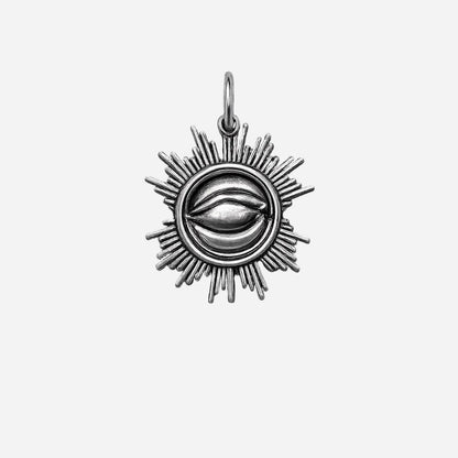 Silver pendant with eye design on a grey background