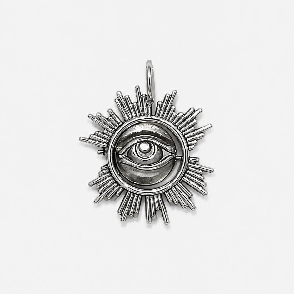 Silver pendant with eye design on a white background