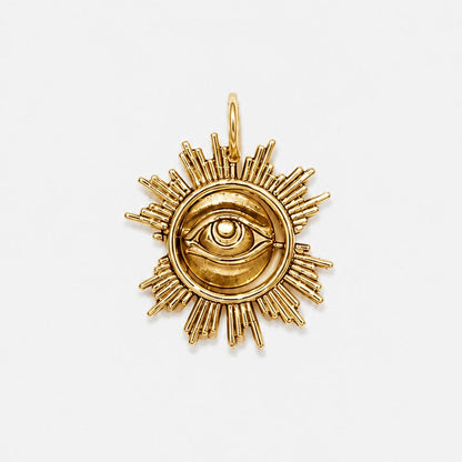 Gold sun-shaped pendant with eye design on a white background